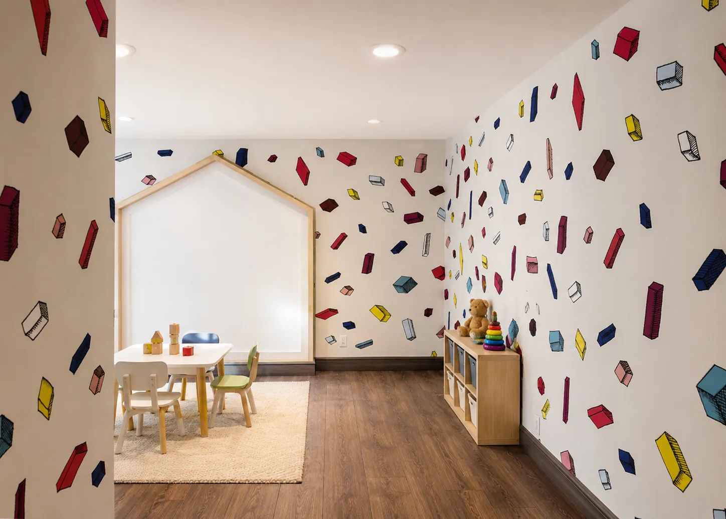 Children's playroom with colorful block-print walls, a play table, and toy storage in an Astoria mixed-use condominium