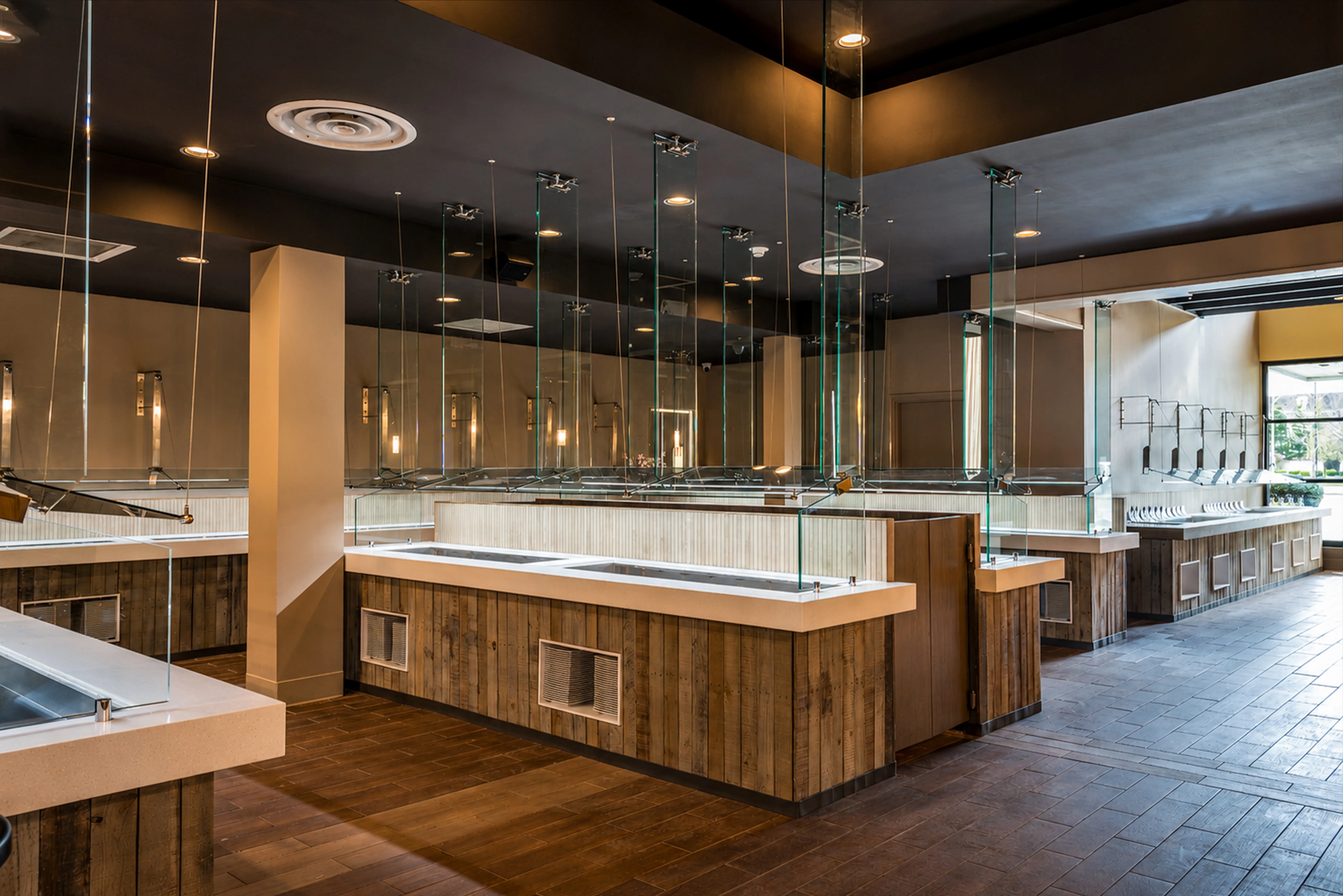 Restaurant buffet and sauce station with reclaimed-wood counters, quartz tops, and hanging glass guards